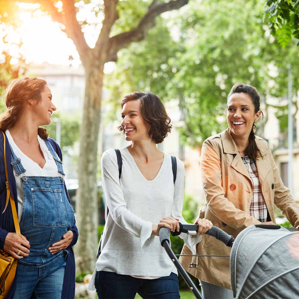 Three women, one pregnant, one pushing a pram Three women, one pregnant, one pushing a pram